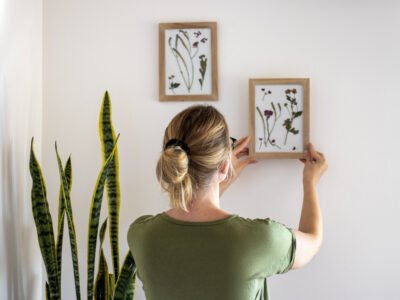 A woman hangs a picture