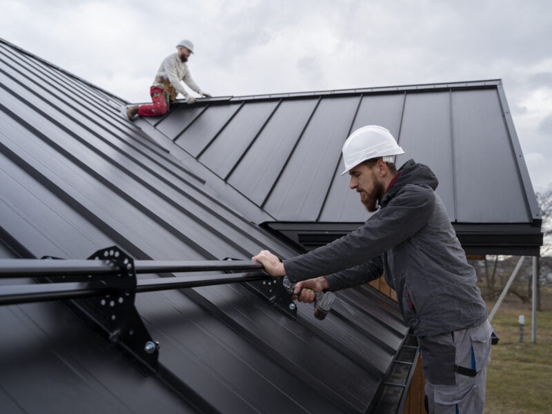 A handyman installs awning
