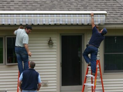A handyman repairs awning