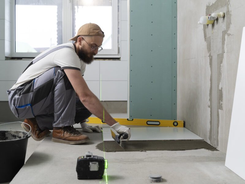 A handyman renovates a bathroom