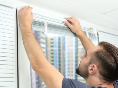 A handyman installs blinds