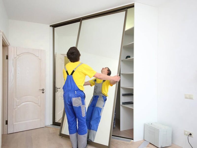 A handyman repairs a cabinet
