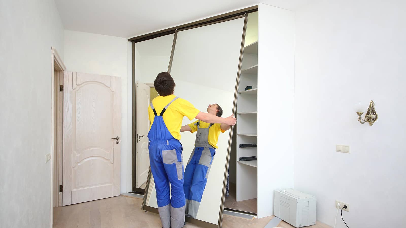 A handyman repairs a cabinet