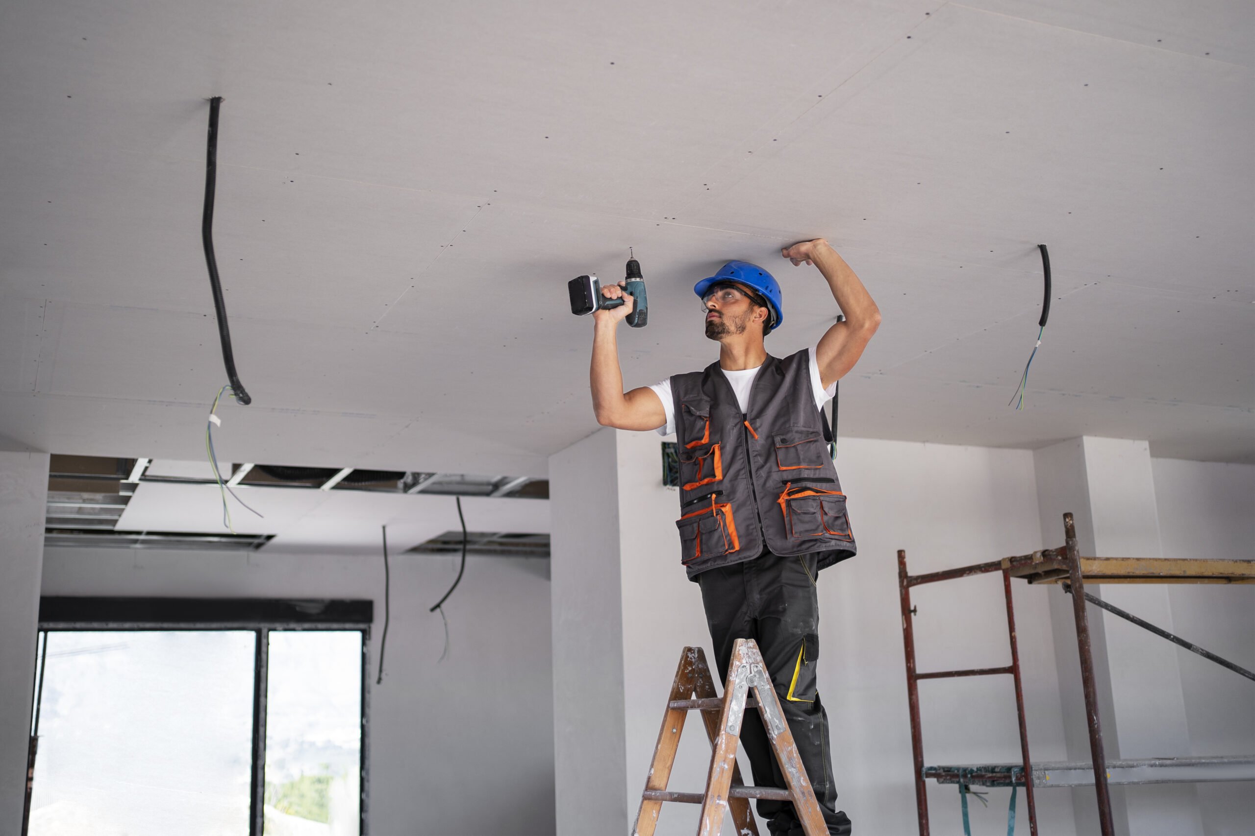 A handyman repairs the ceiling