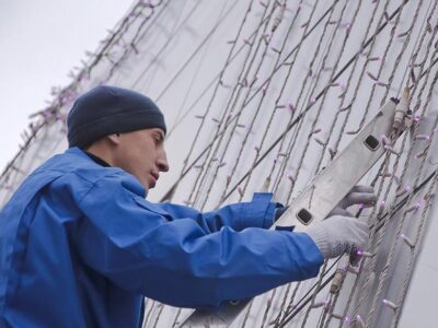 A handyman installs Christmas Light