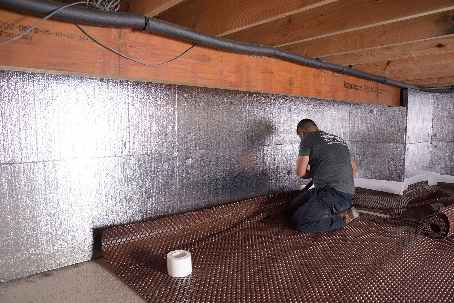 A worker repairs a crawlspace