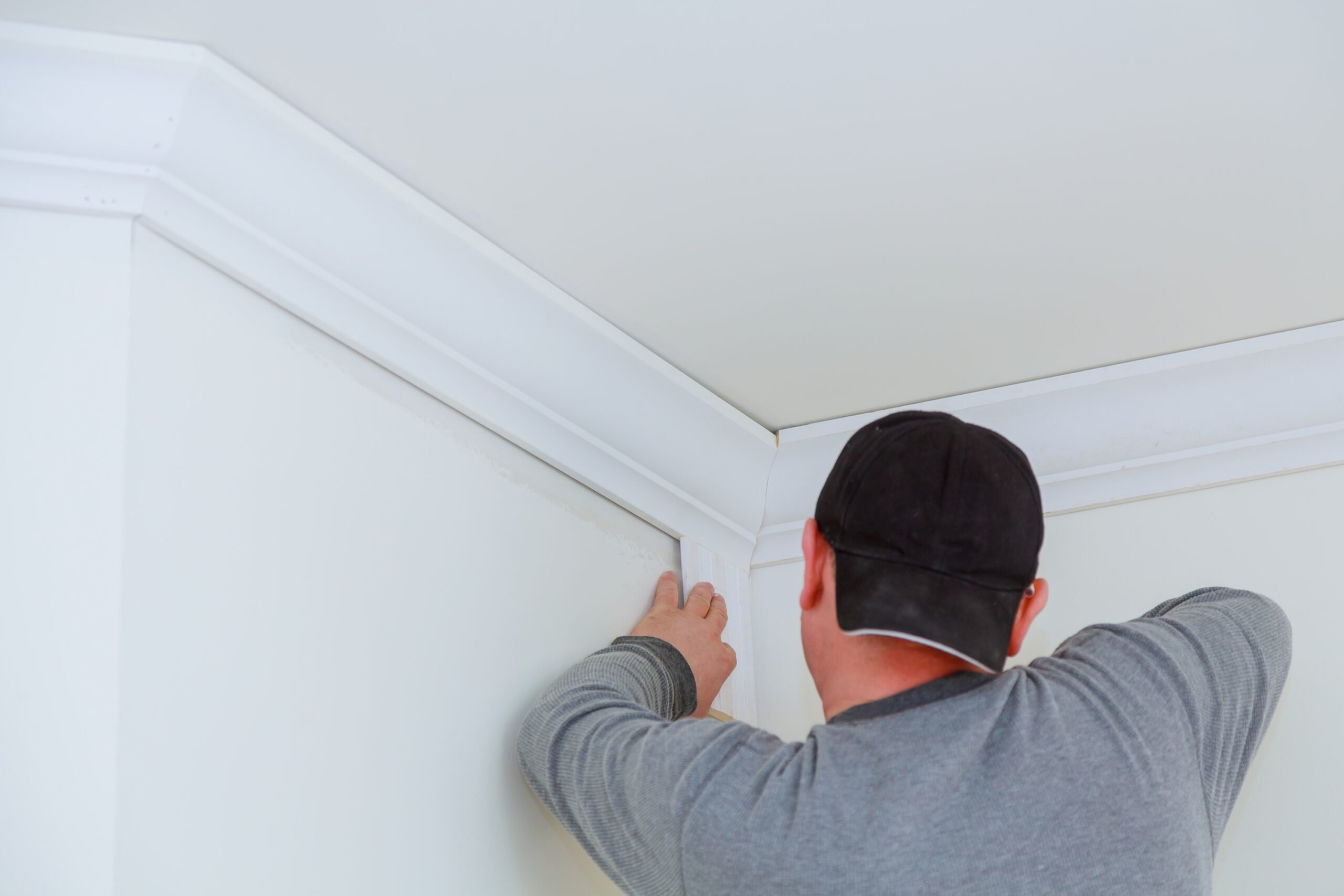 A handyman installs crown molding