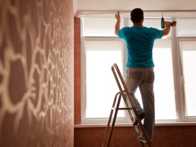 A handyman hangs curtain rod