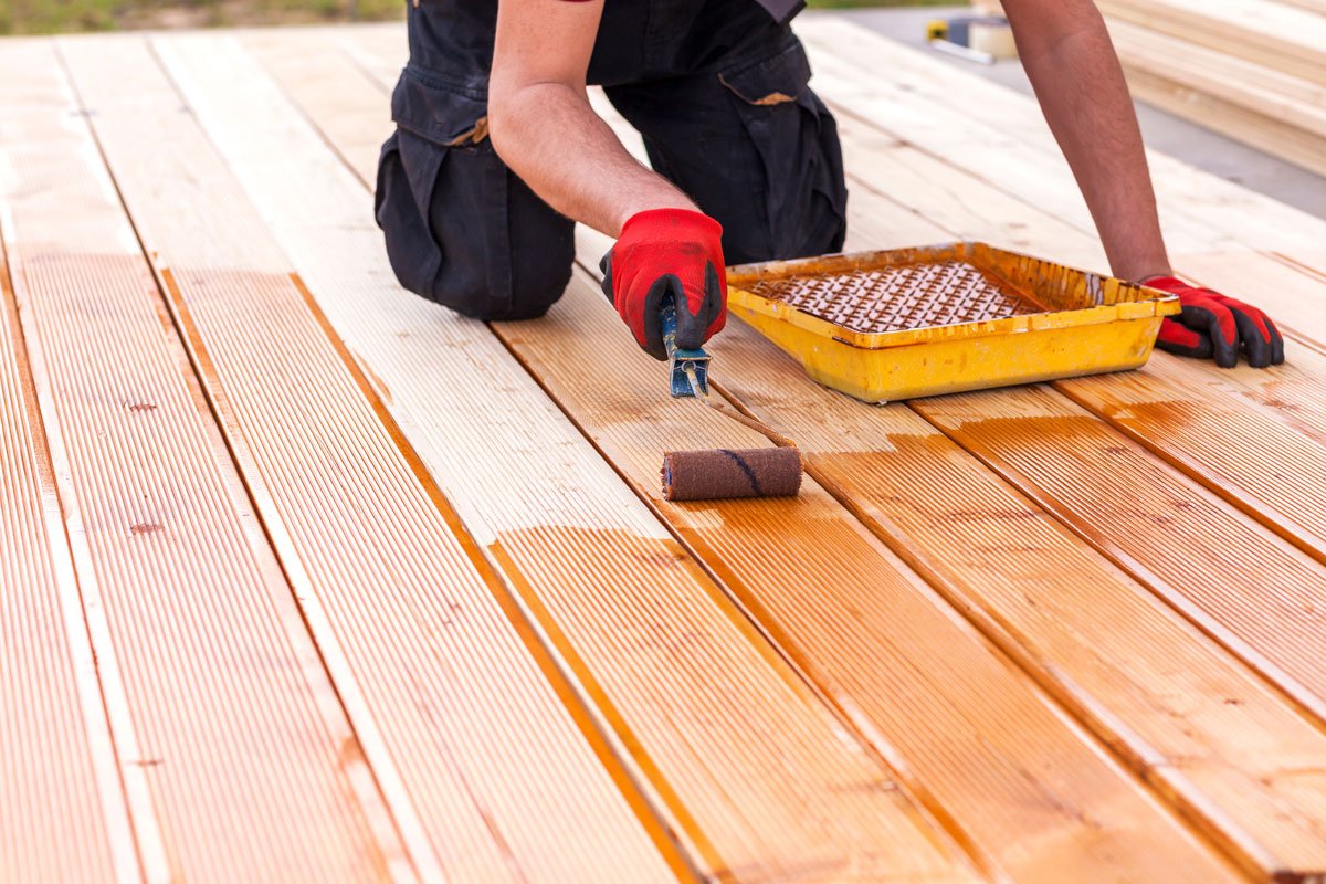 A handyman stains decks
