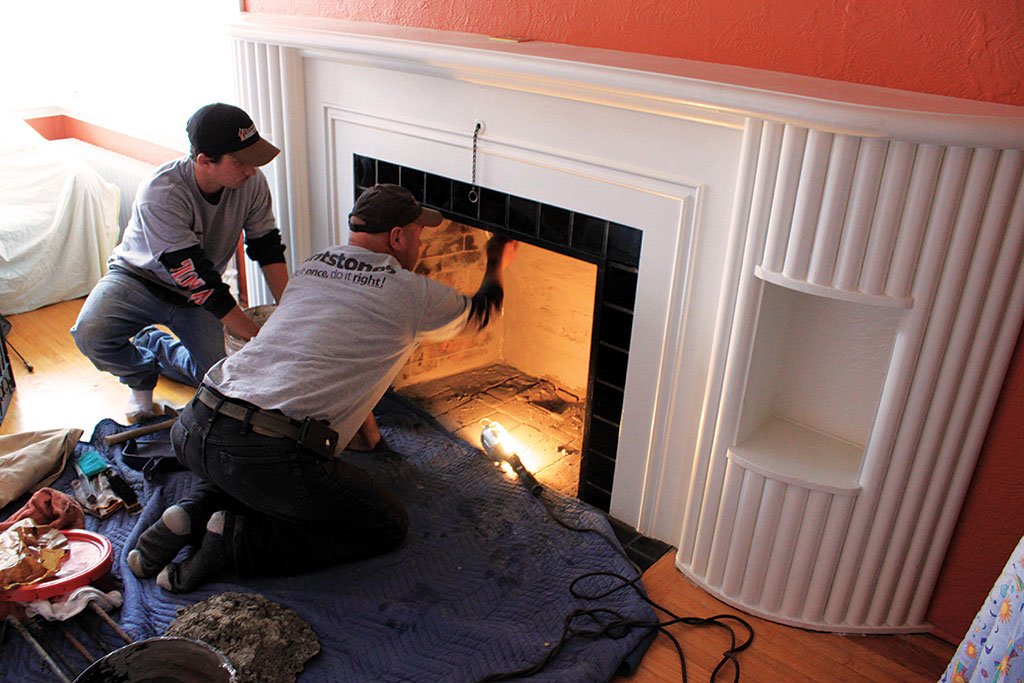 Workers install a fireplace