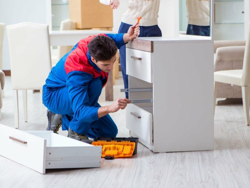A handyman assembles furniture