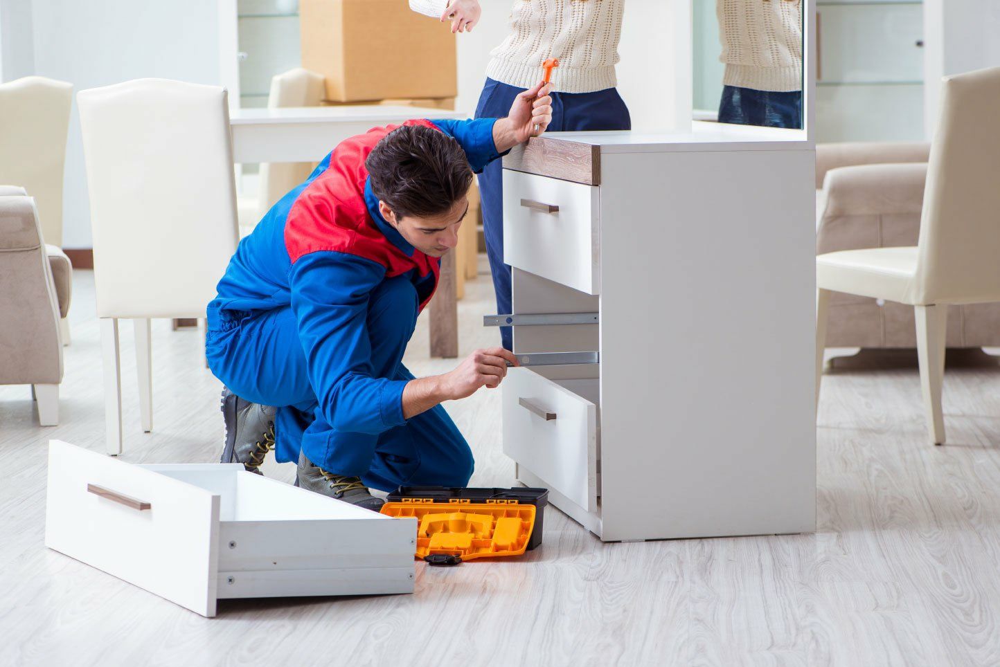A handyman assembles furniture
