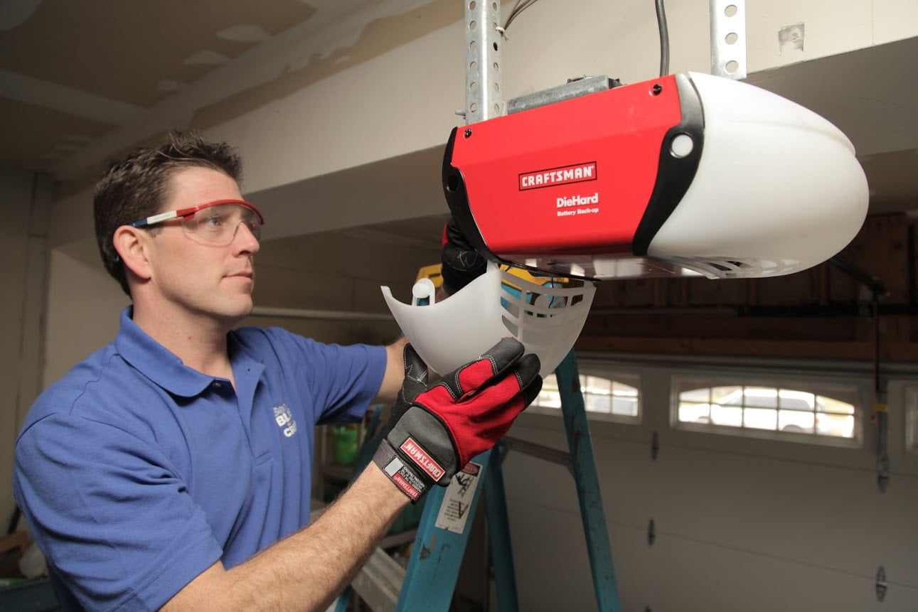 A worker installs a garage door opener