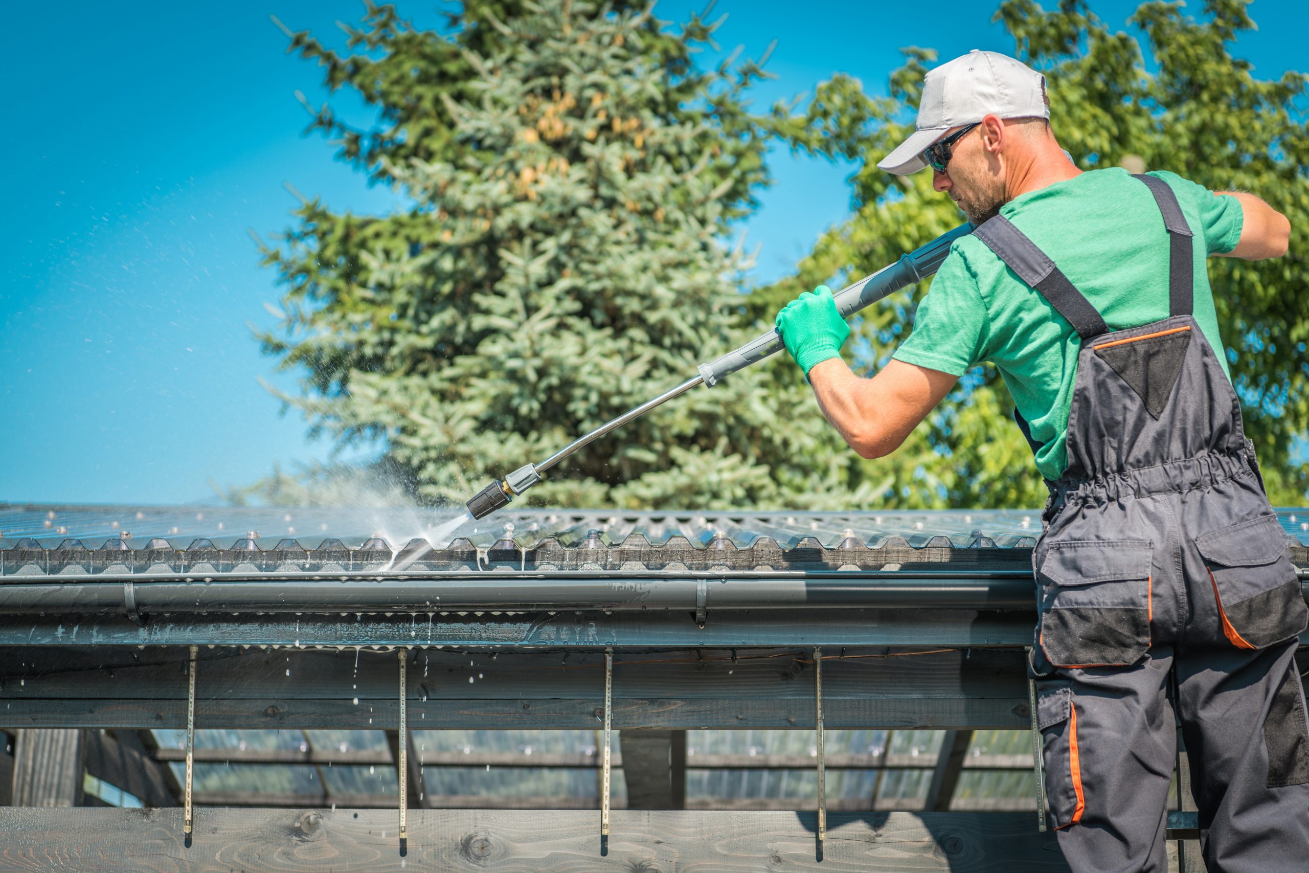 A worker cleans a gutter