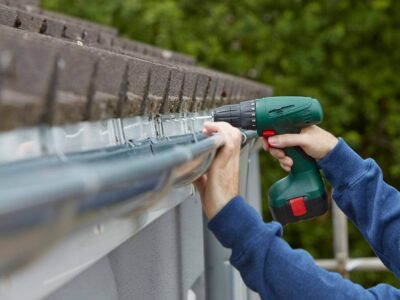A worker repairs a gutter