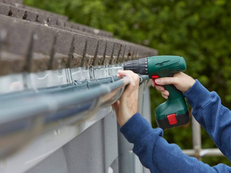 A worker repairs a gutter