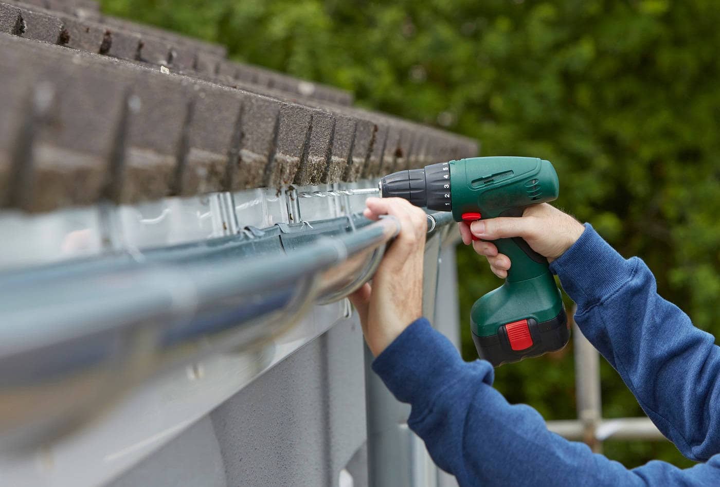 A worker repairs a gutter