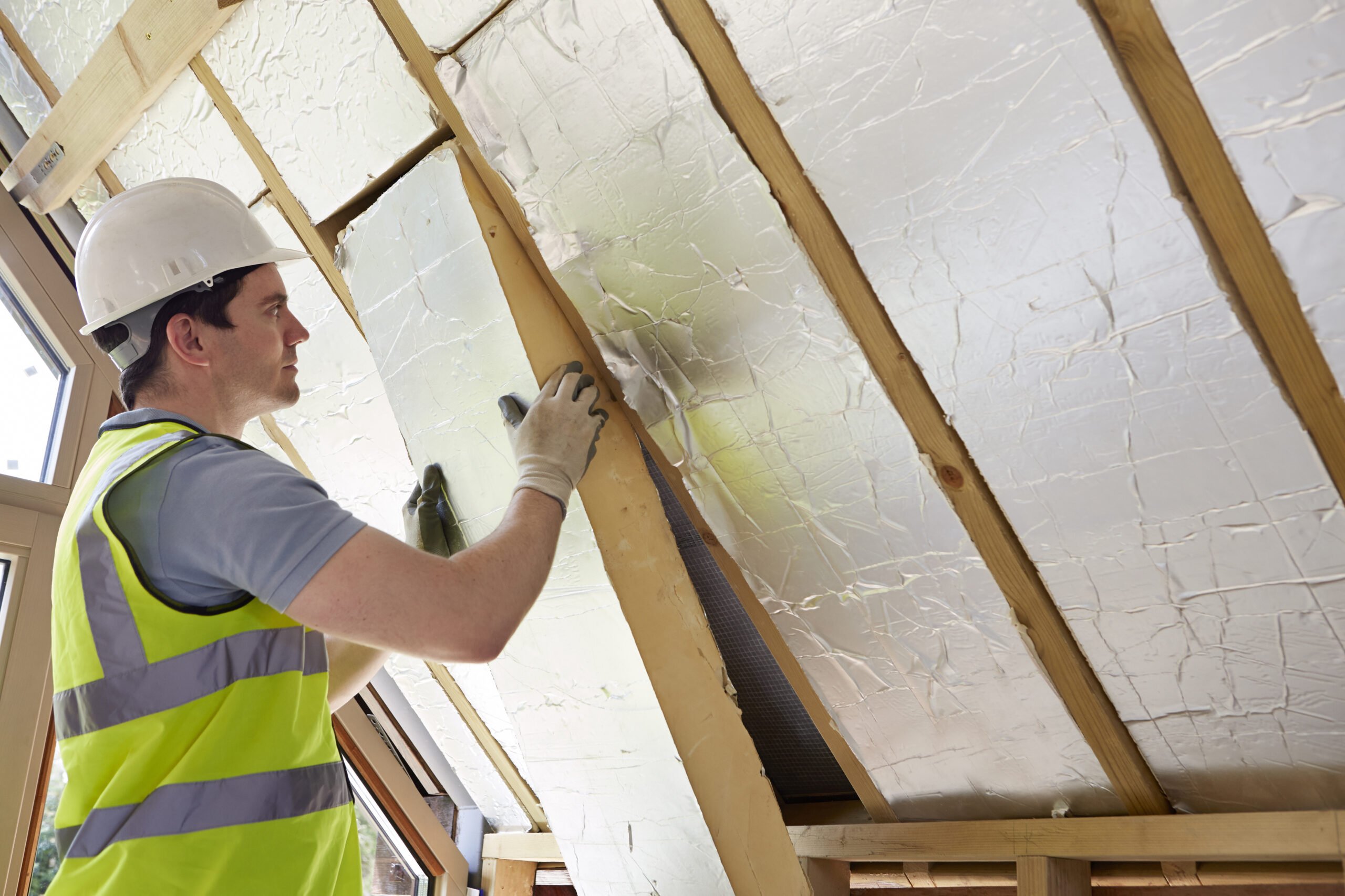 A worker installs insulation