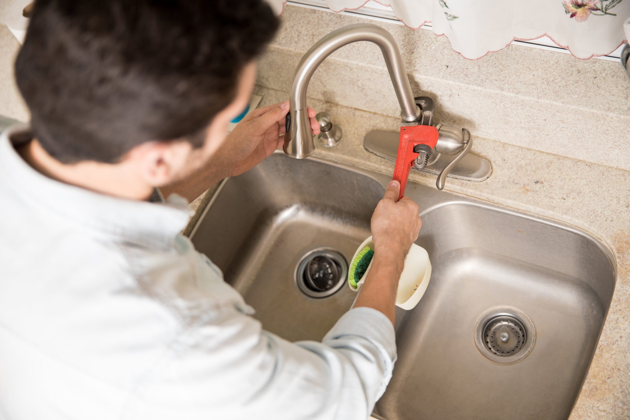 A plumber repairs a leaky faucet