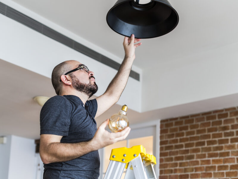 A worker changes a light bulb