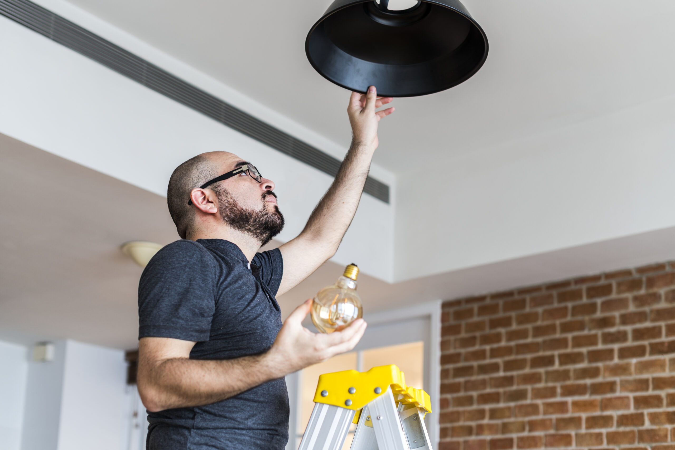 A worker changes a light bulb