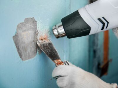A handyman removes a paint