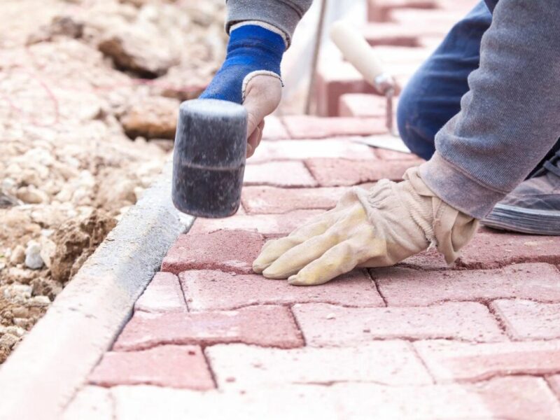 A handyman installs a paver patio
