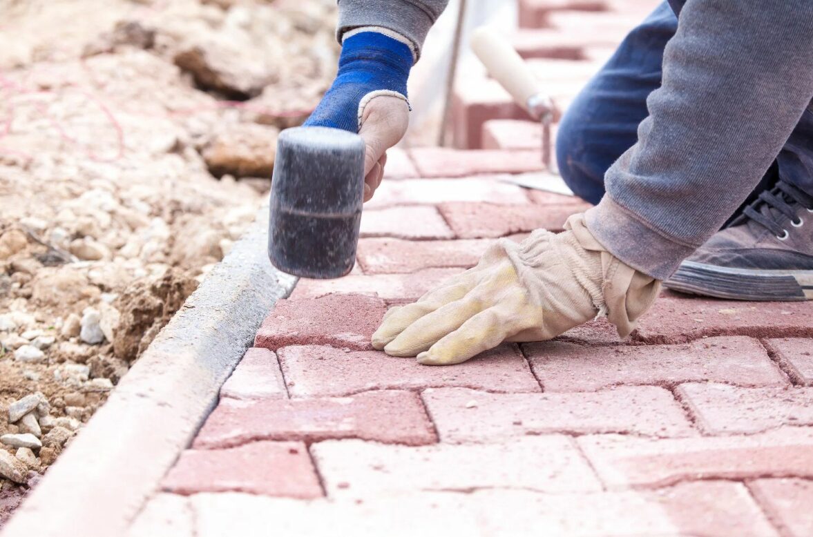 A handyman installs a paver patio