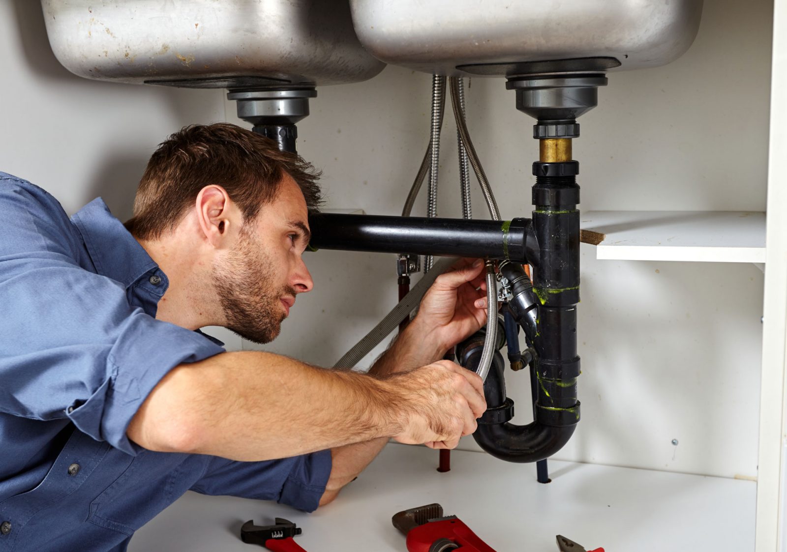 A plumber repairs a sink