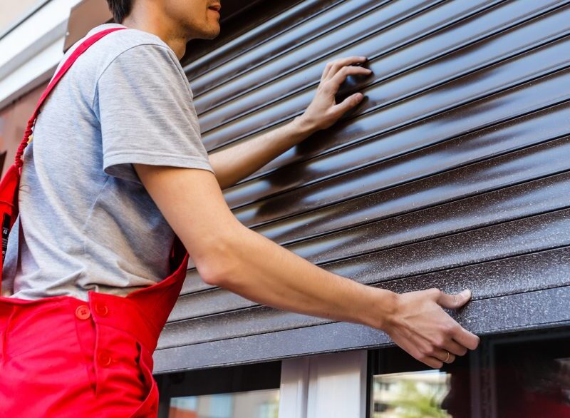 A handyman installs a shutter