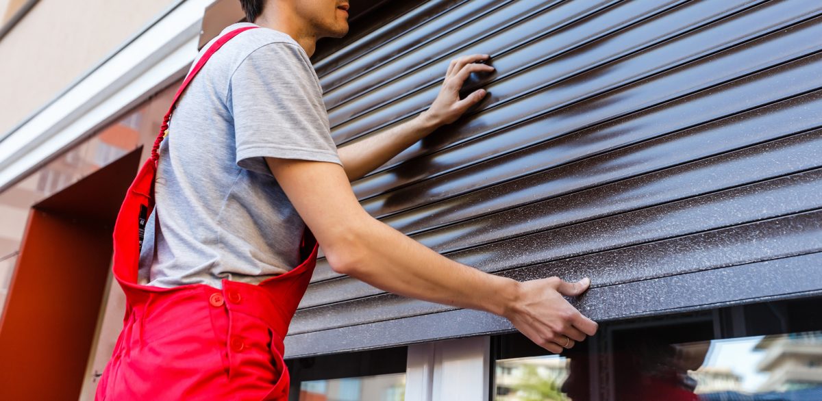 A handyman installs a shutter