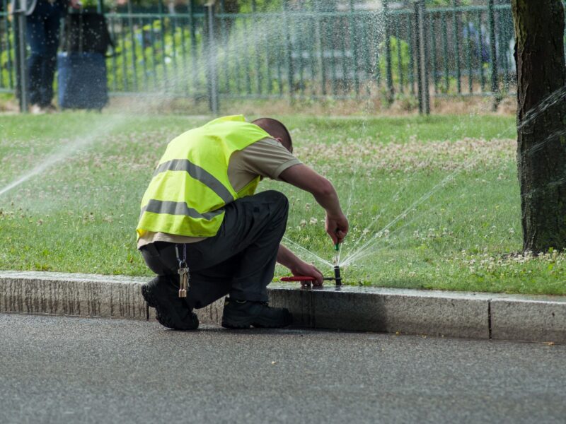 A worker repairs a sprinkler system