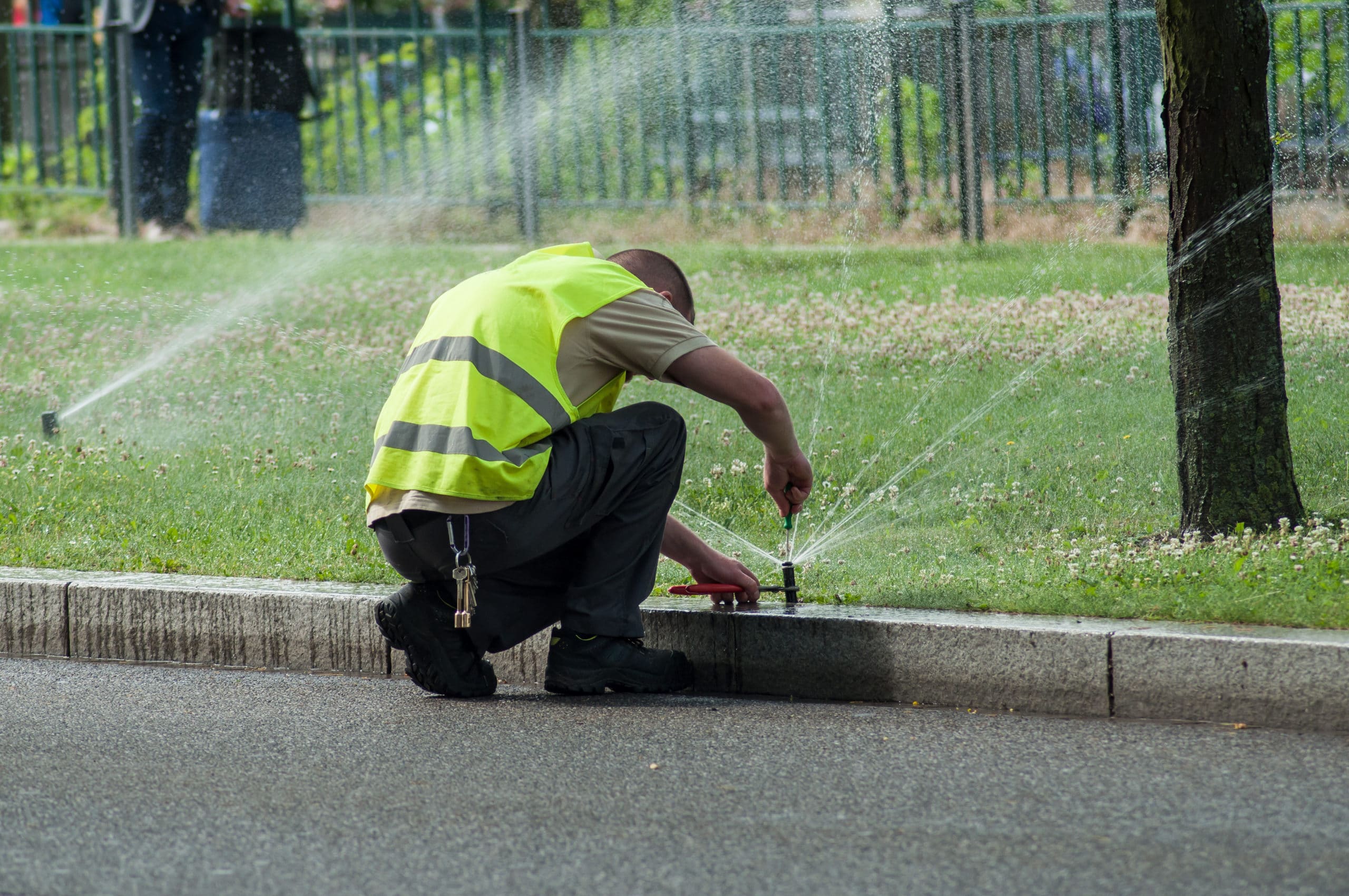 A worker repairs a sprinkler system