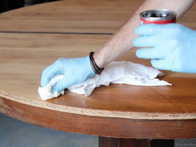A worker removes stains from a table