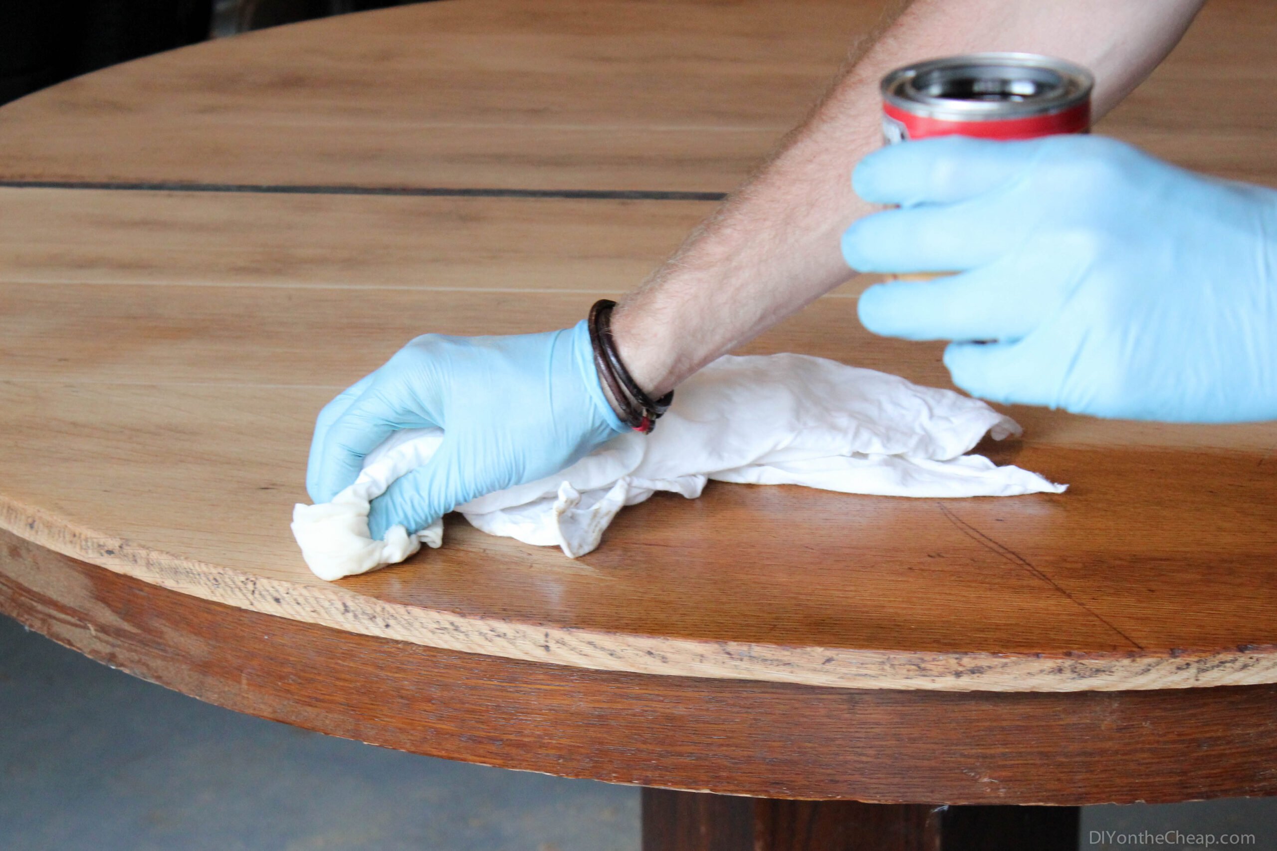 A worker removes stains from a table