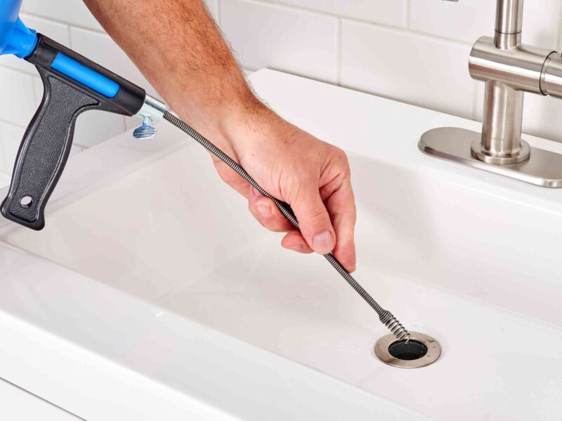 A plumber unclogs a drain