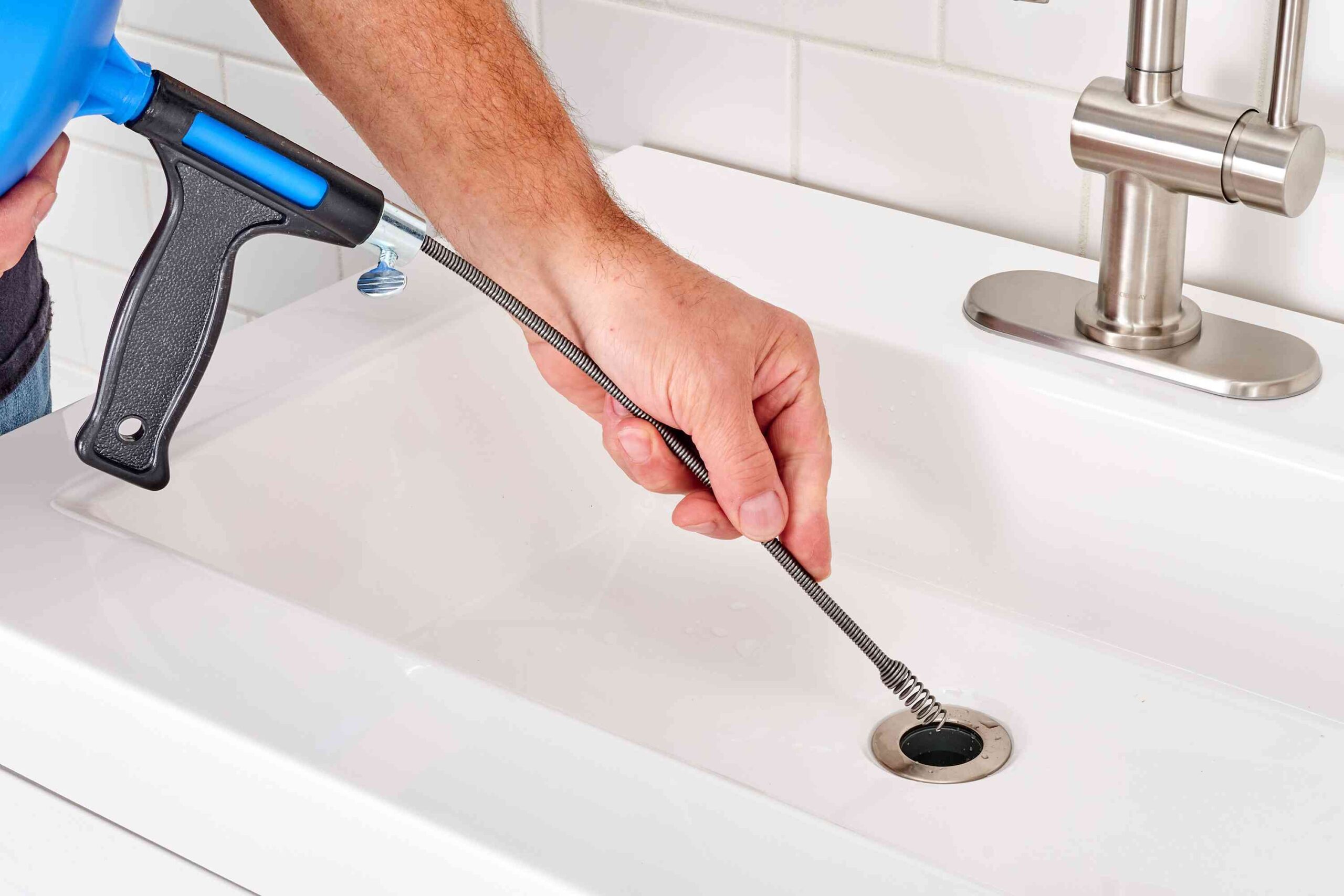 A plumber unclogs a drain