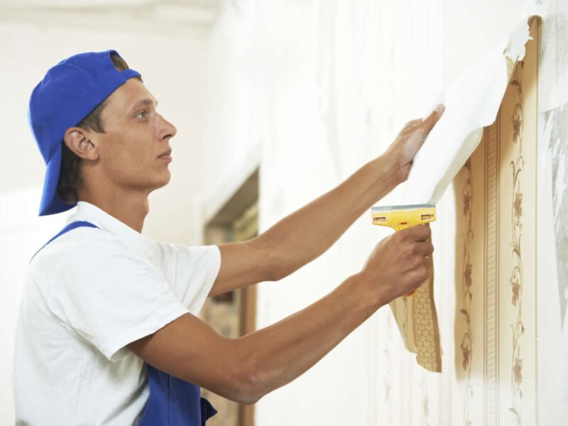 A handyman removes wallpapers