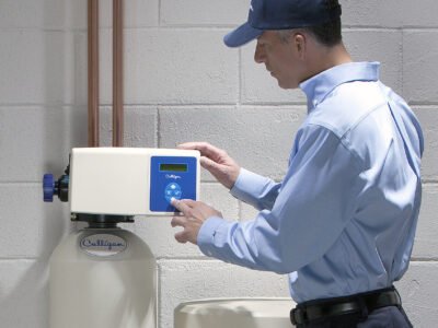 A handyman repairs a water softener