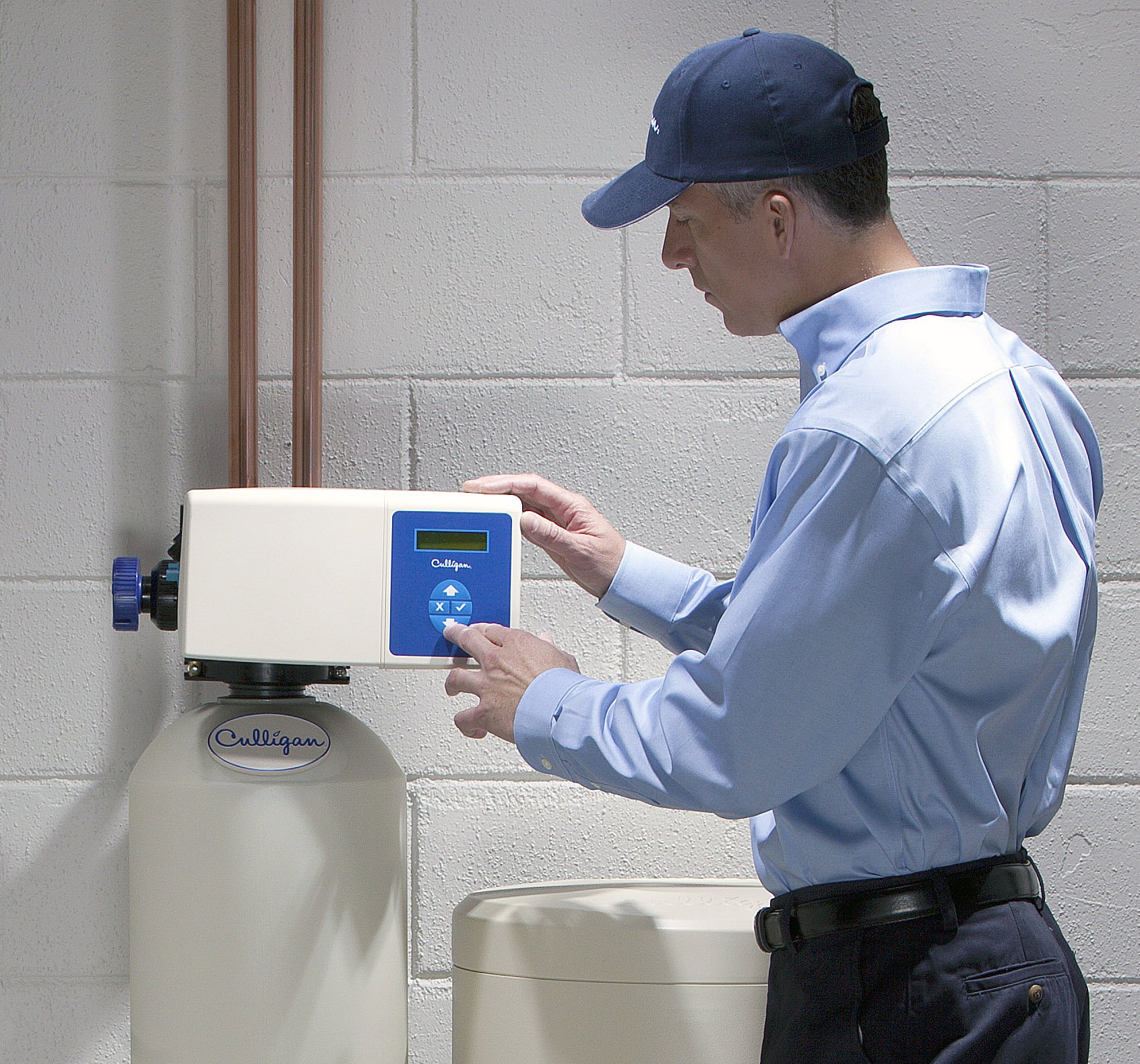 A handyman repairs a water softener