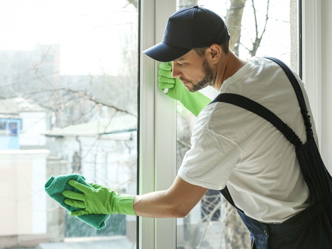 A handyman cleans windows
