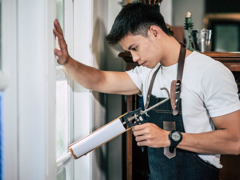A worker repairs a window frame